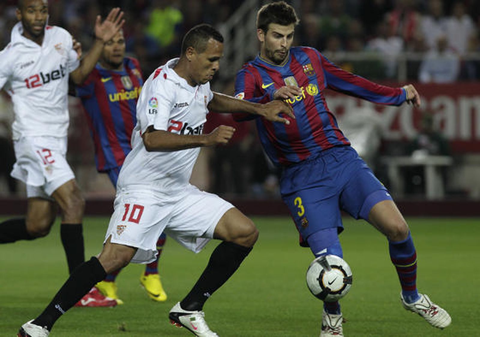 Luis Fabiano trata de marcharse de Piqué. / Antonio Pizarro