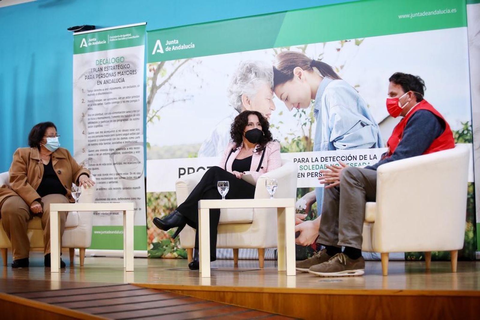 La consejera de Igualdad, Políticas Sociales y Conciliación, Rocío Ruiz, flanqueada por la gaditana Chari Luque y por el voluntario de Cruz Roja Ángel Hurtado.