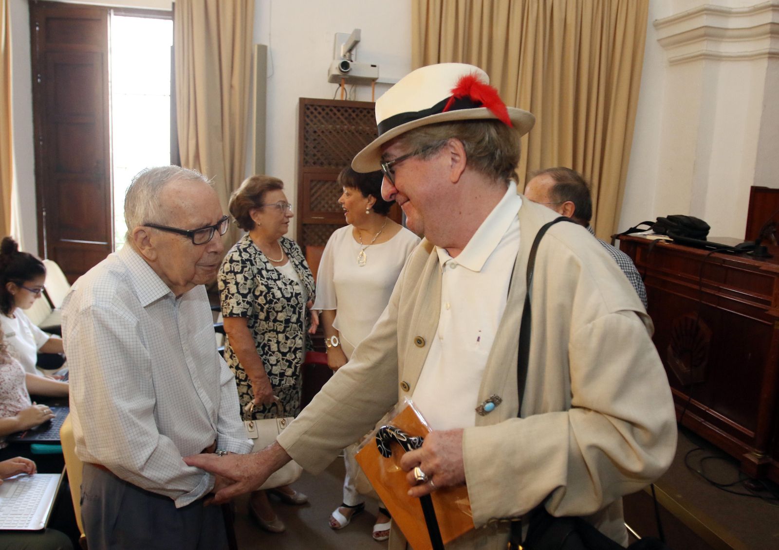 Luis Antonio de Villena saluda a Pablo García Baena antes de su conferencia.