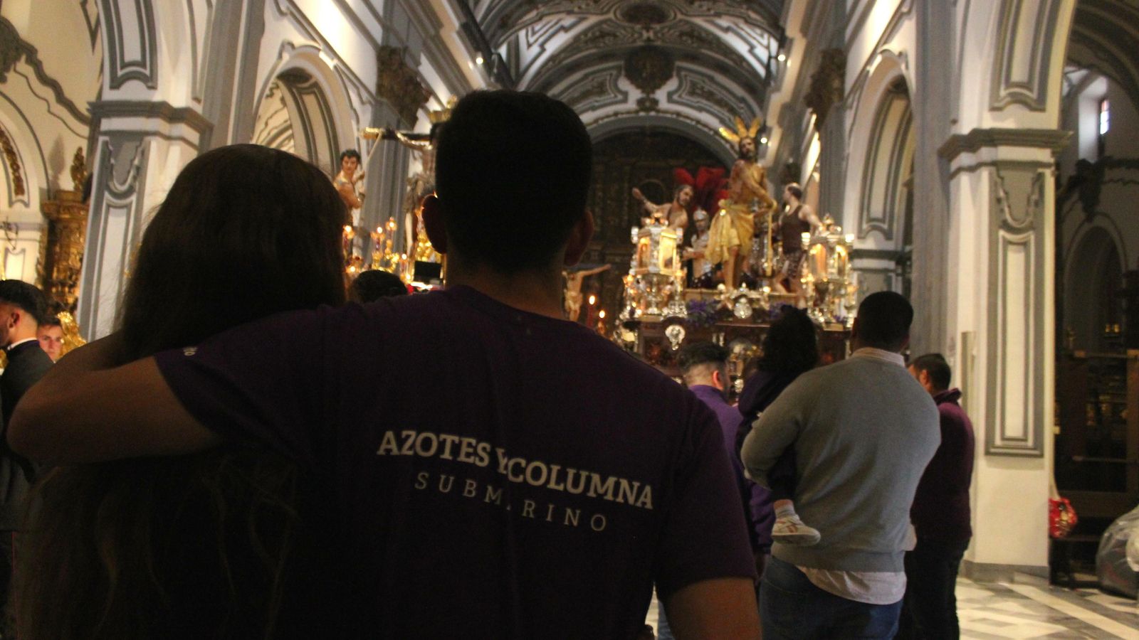 Un portador abraza a su novia frente a Exaltación y Azotes y Columna.