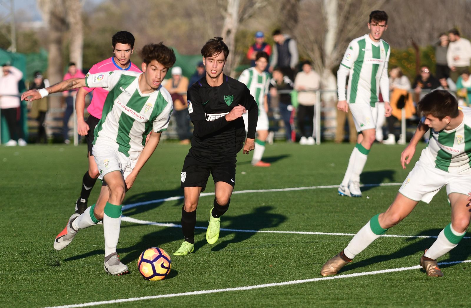 Un jugador del Córdoba juvenil supera a uno del Málaga.