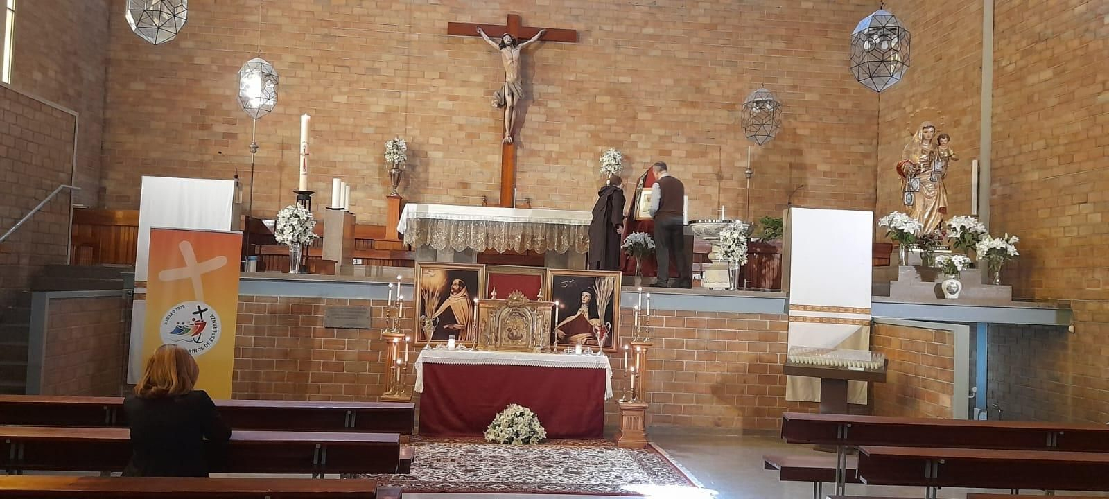 El sacristán de la iglesia Stella Maris coloca una cuadro de Francisco I