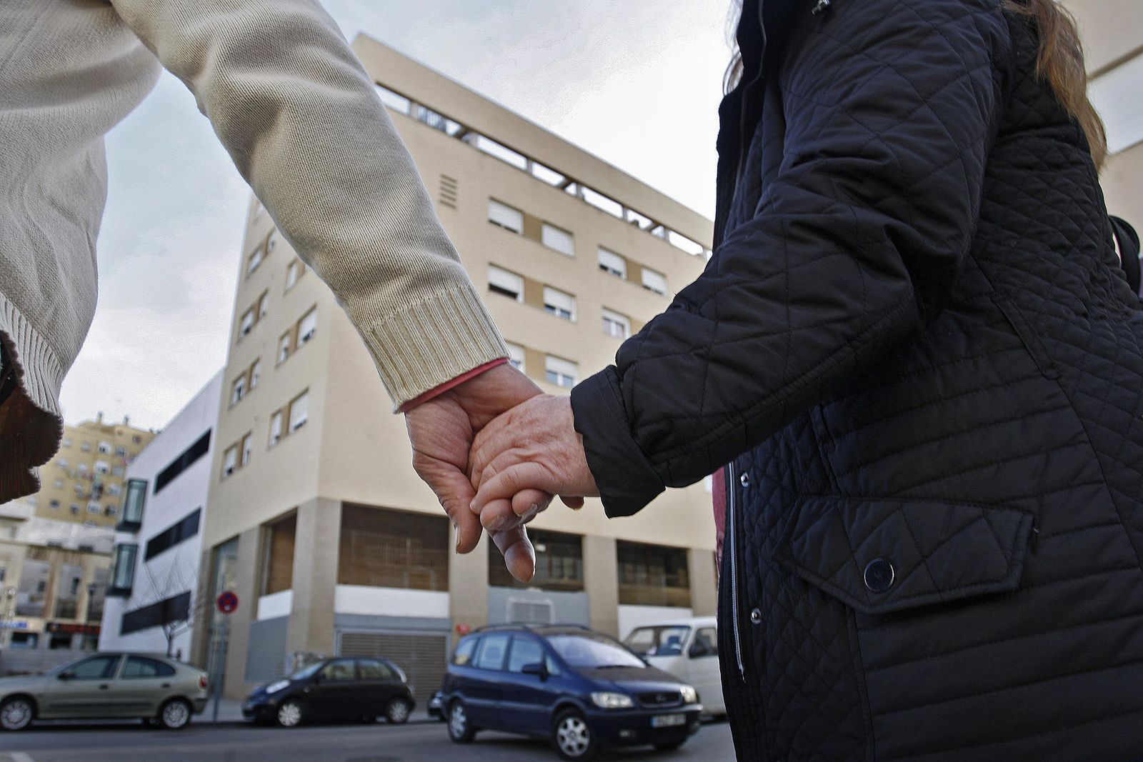 Una pareja que compró un piso en el edificio de la Corrala observa el bloque donde tenía pensado vivir.