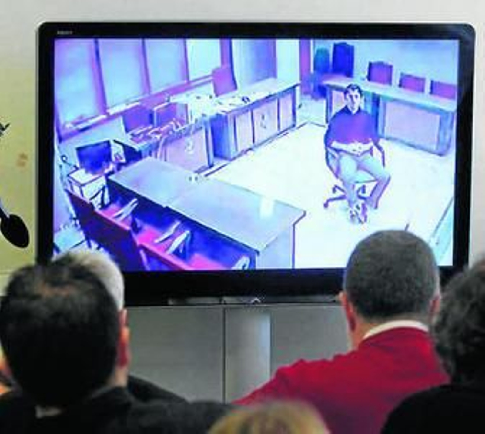 Varios periodistas siguen por televisión una de las declaraciones.