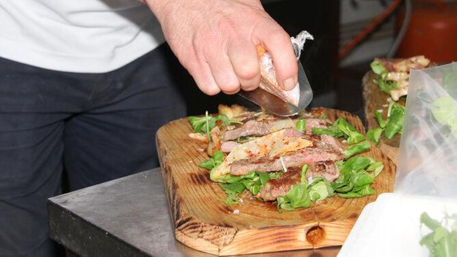 Individuo preparando un plato degustación para la Semana del Retinto