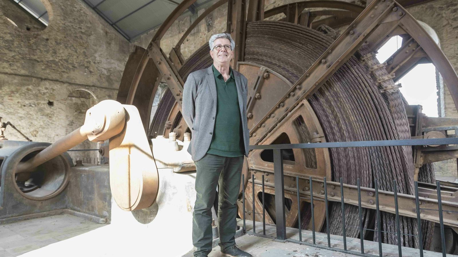 Julián Sobrino posa ante la máquina de vapor que se conserva en el Pozo 5.