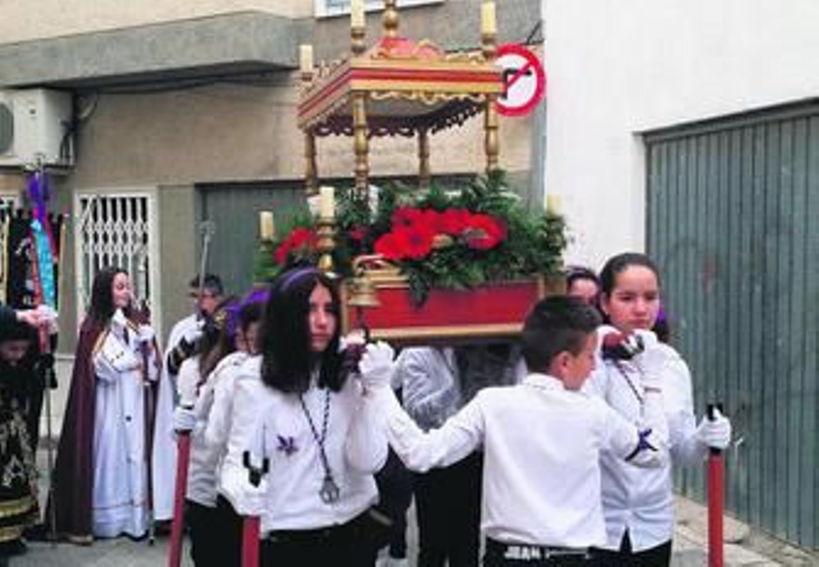Los pequeños portan el paso del Santo Sepulcro.