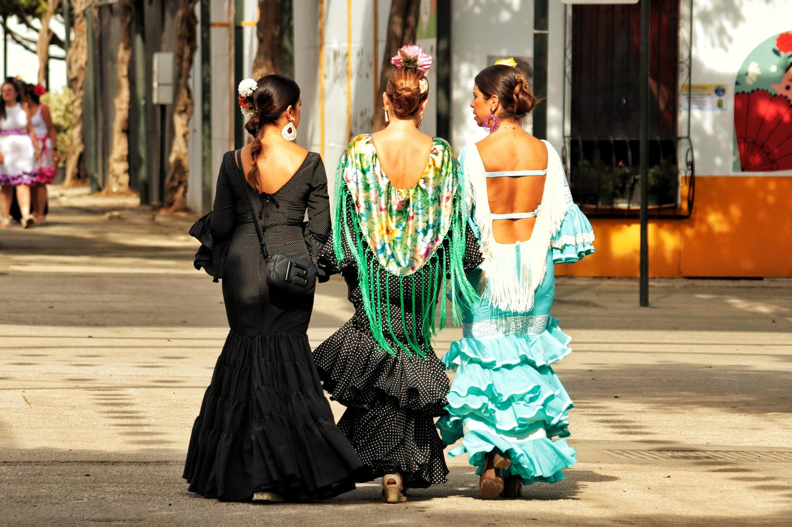 Imagen de tres mujeres vestidas de flamenca en la Feria de Málaga