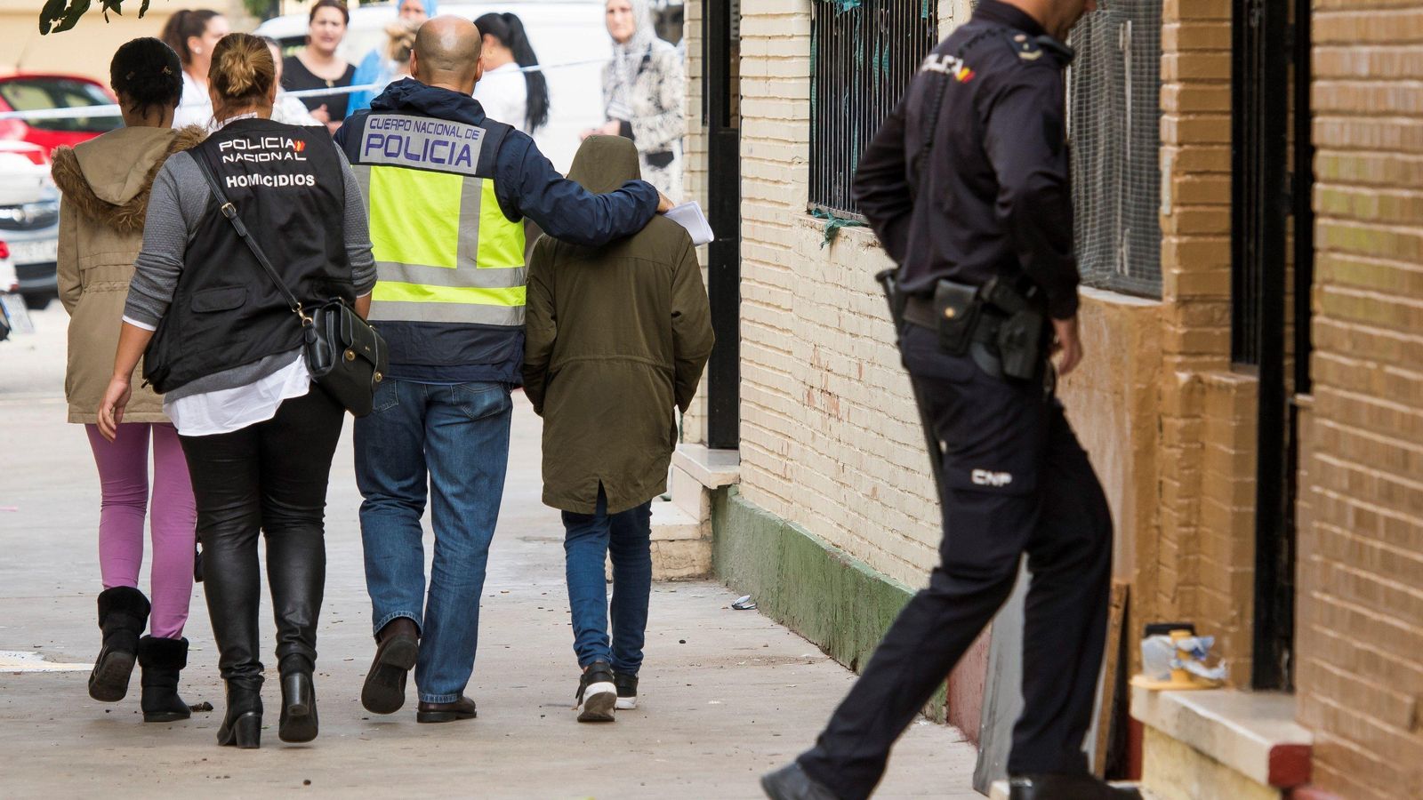 Un policía nacional se lleva al hijo de la última víctima de la violencia machista.