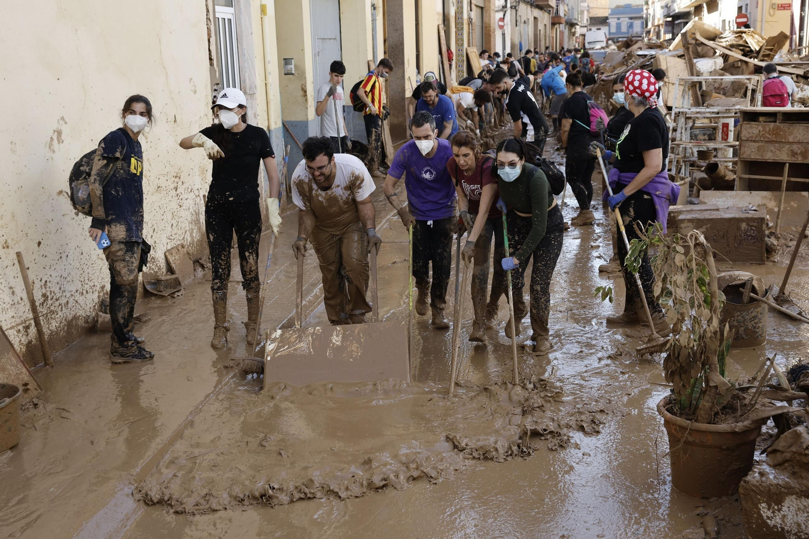 Voluntarios retirando lodo de una calle del municipio de Paiporta, uno de los más afectados por la DANA.