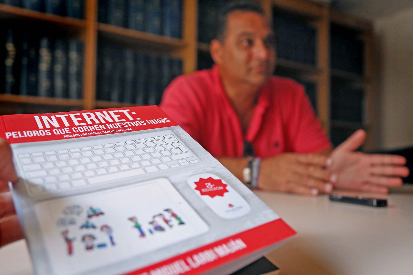 Luis Miguel Larbi Maján, con un ejemplar de 'Internet: peligros que corren nuestros hij@s', durante la entrevista.