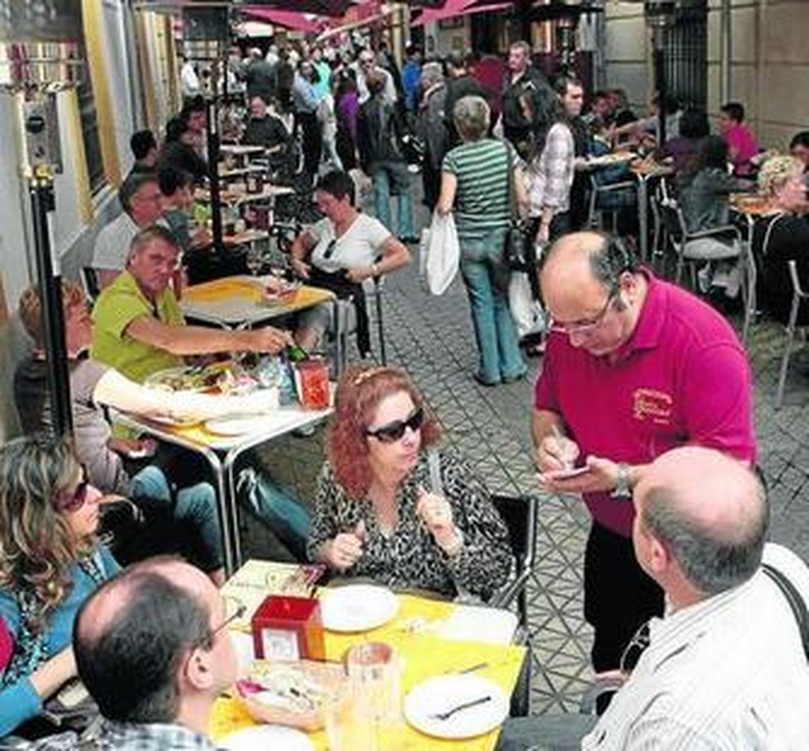 Un camarero atiende en una terraza en Sevilla.