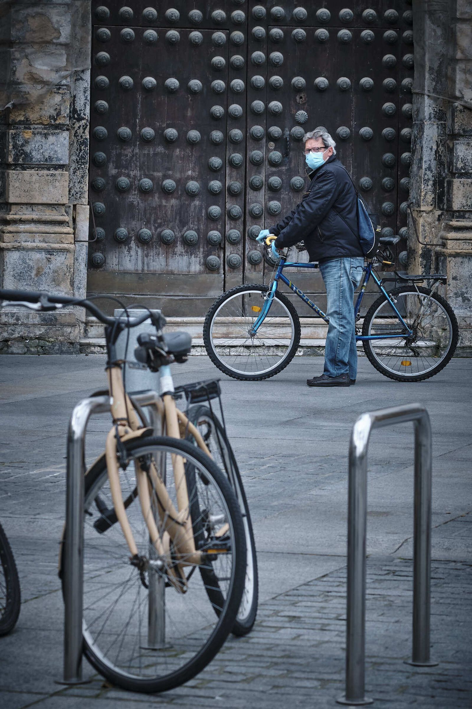 Un hombre en la plaza de San Juan de Dios, aguarda la cola del super con bicicleta y mascarilla.