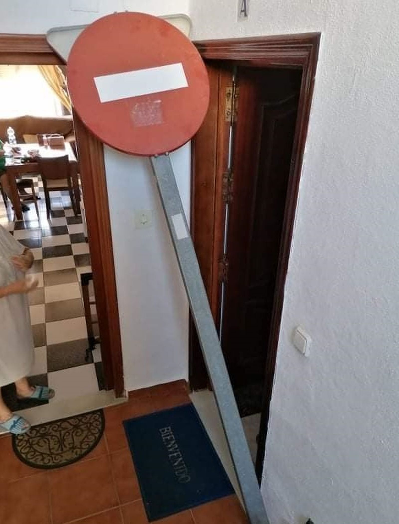 La señal de prohibido arrojada entre las puertas de dos viviendas de la barriada Bazán.