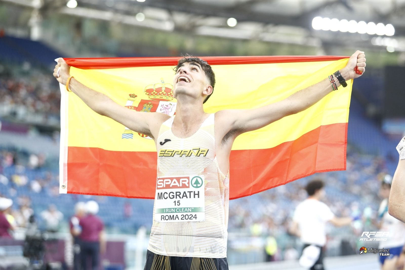 Paul McGrath celebra con la bandera de España su victoria en el 20 km. marcha dentro del Estadio Olímpico de Roma.