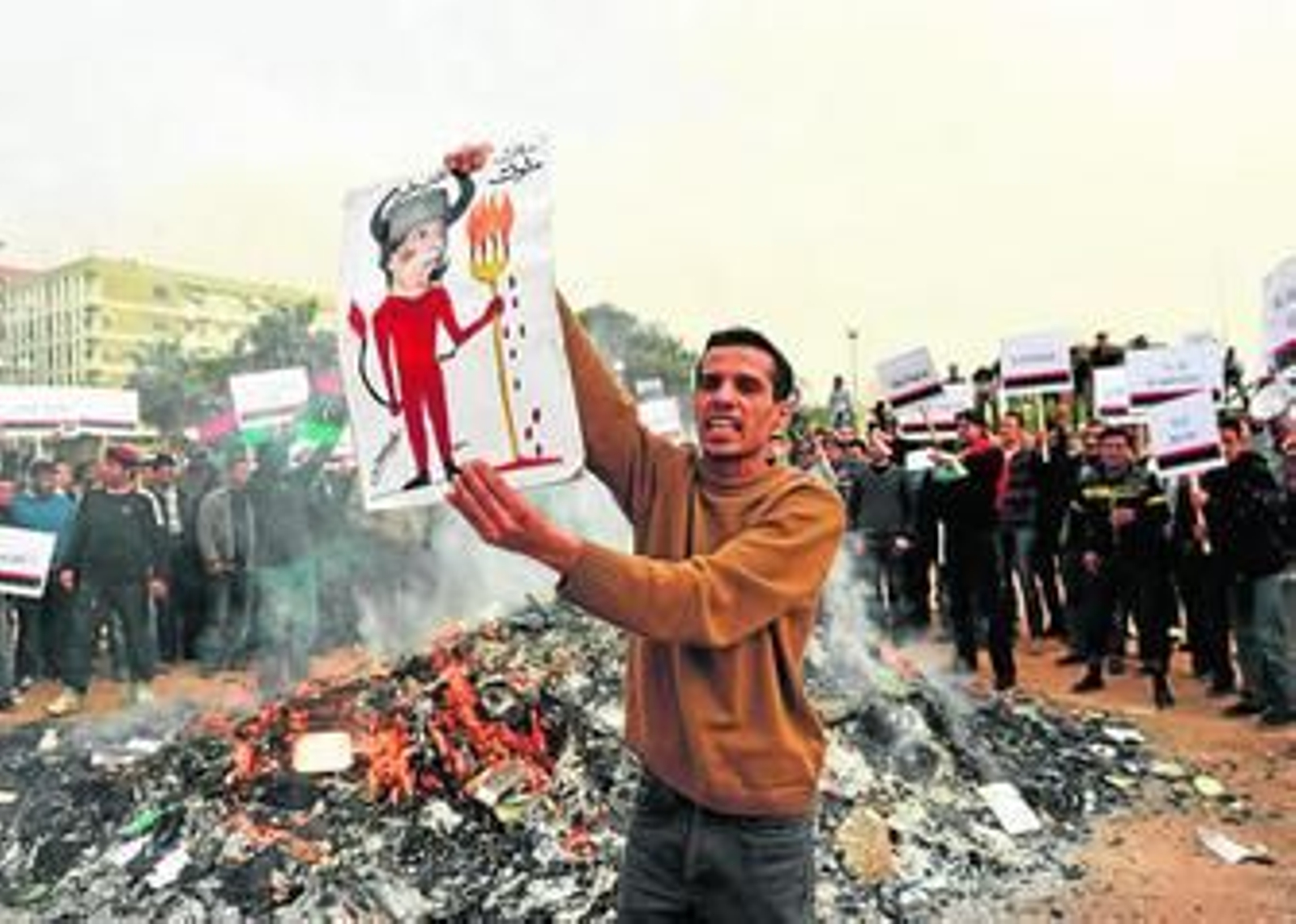 Un joven libio muestra una caricatura de Gadafi identificado como un demonio, en la liberada ciudad de Bengasi.