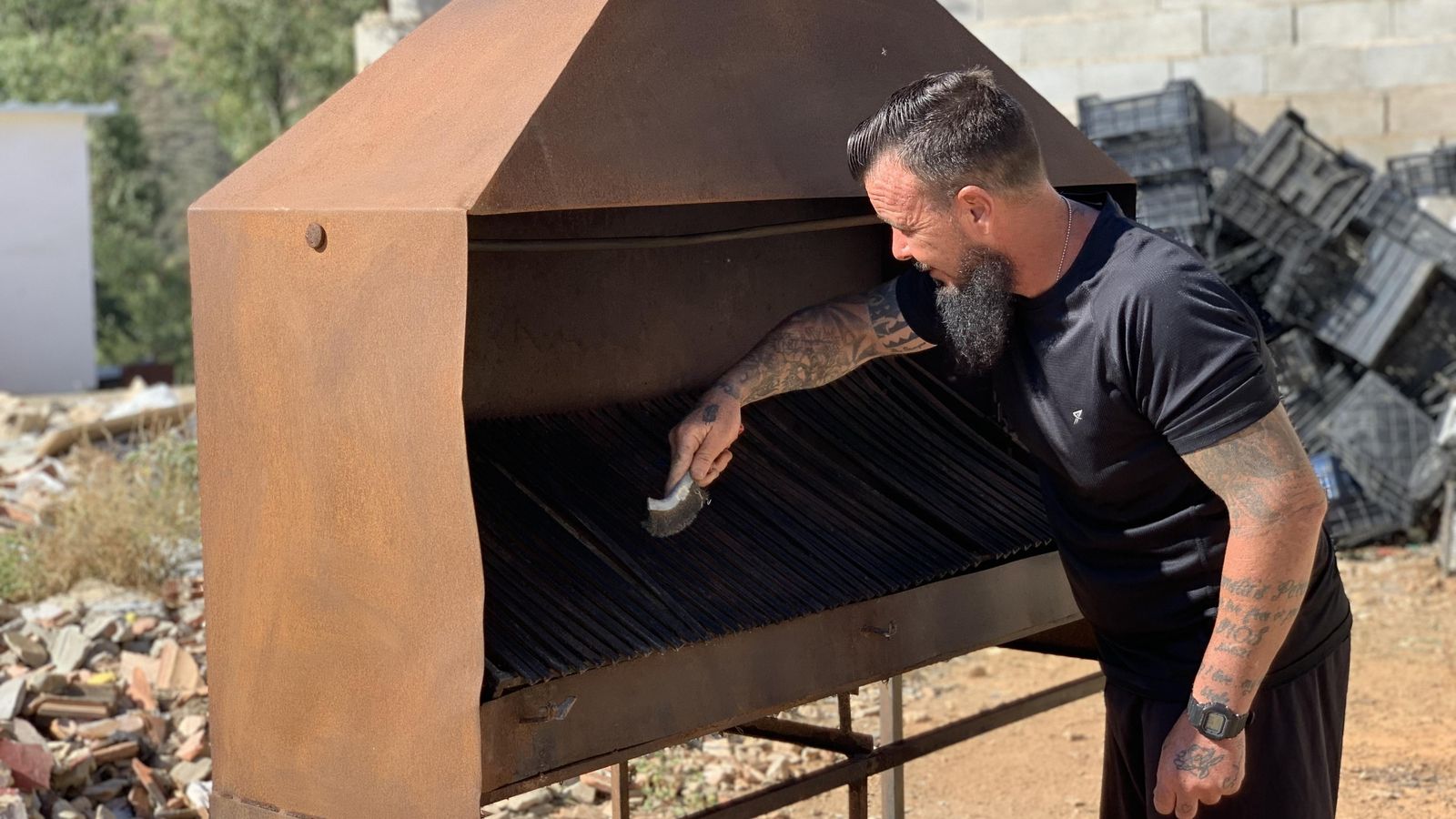 Gustavo limpiando una barbacoa en 'La Casa de la Buena Vida'.