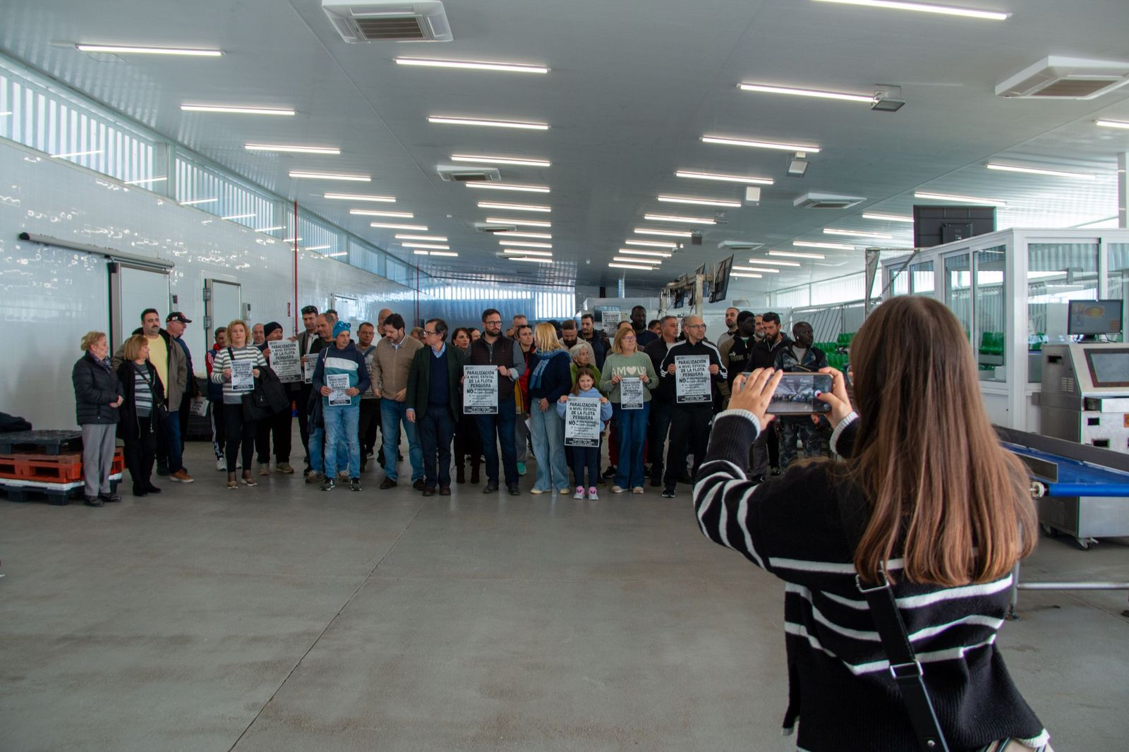 Una mujer hace una foto de la concentración de los pescadores en Motril
