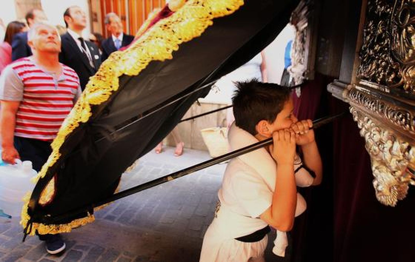 Un niño, ya tocado por el arte costalero, observa a sus mayores bajo el mismísimo manto de la Virgen de la Paz en su Mayor Aflicción.

Foto: miguel ángel gonzález