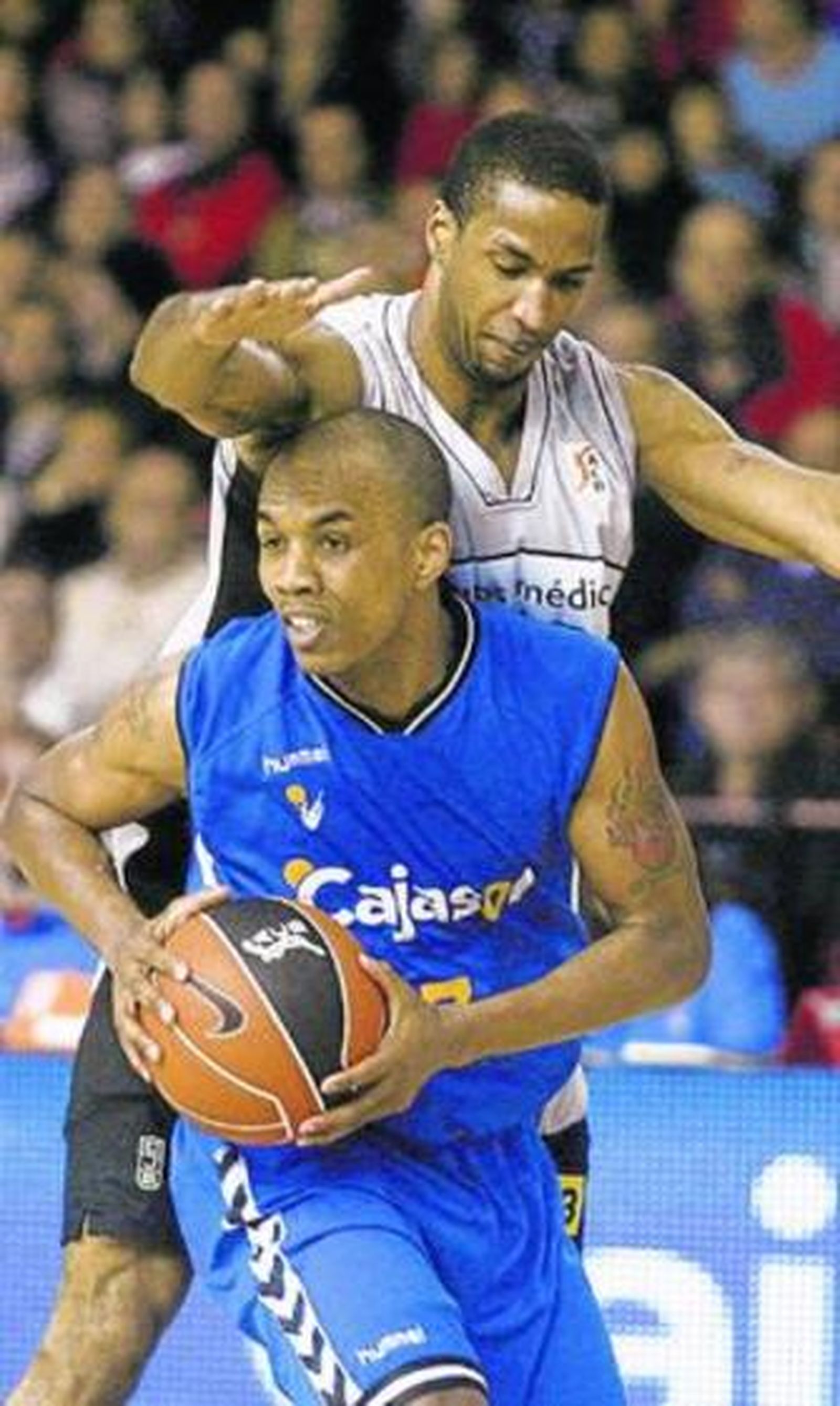 Ellis busca un compañero al que pasar el balón presionado por el ex cajista Tucker.