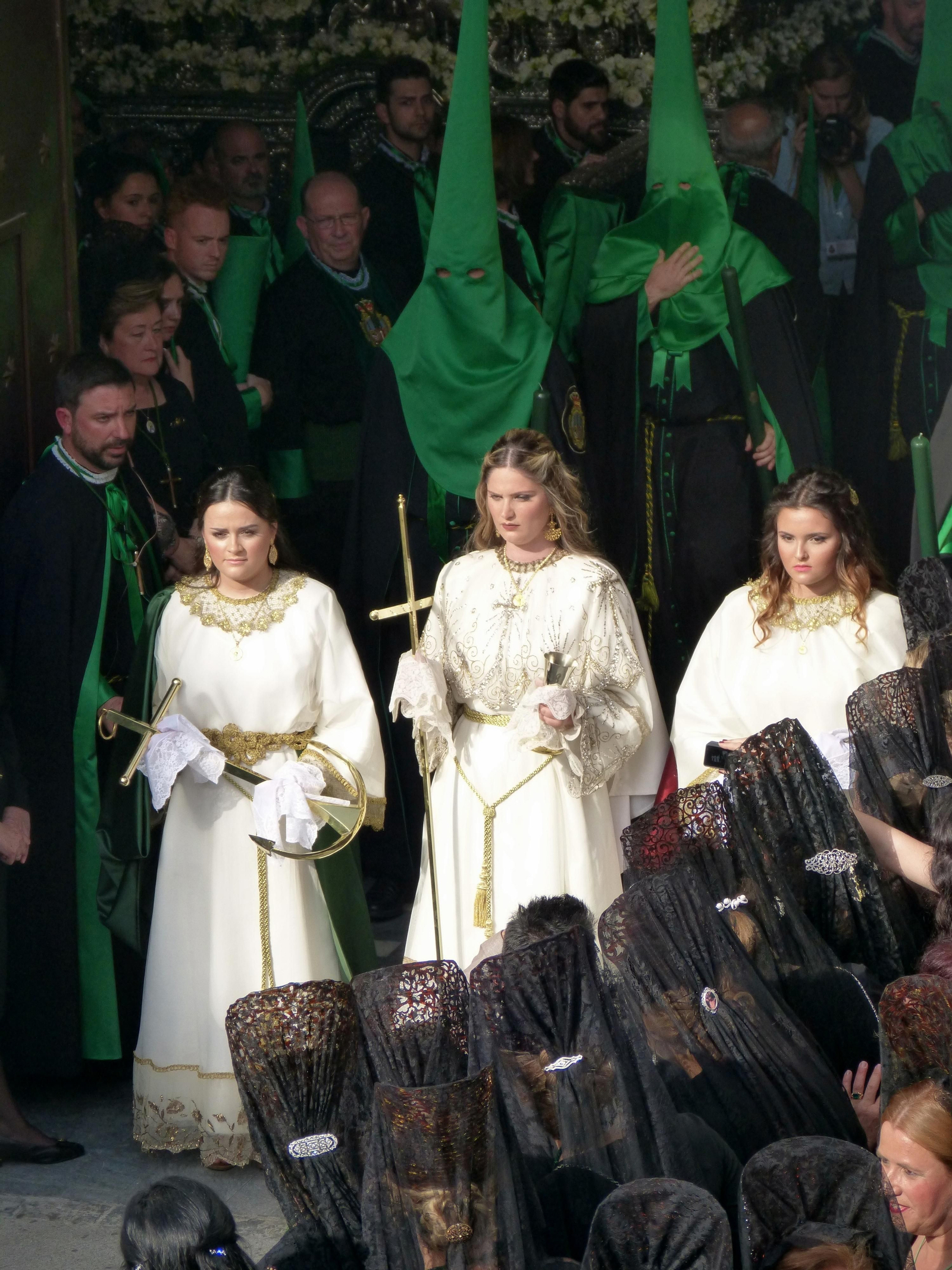 Mujeres ataviadas de mantilla contemplan la salida de las Tres Virtudes Teologales.