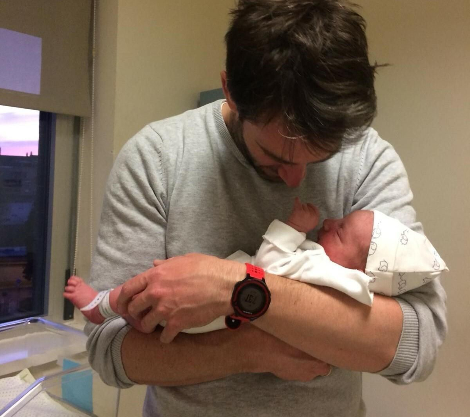 El padre de Gael, John Fisher, sostiene a su bebé nacido el primer día de estado de alarma en España.