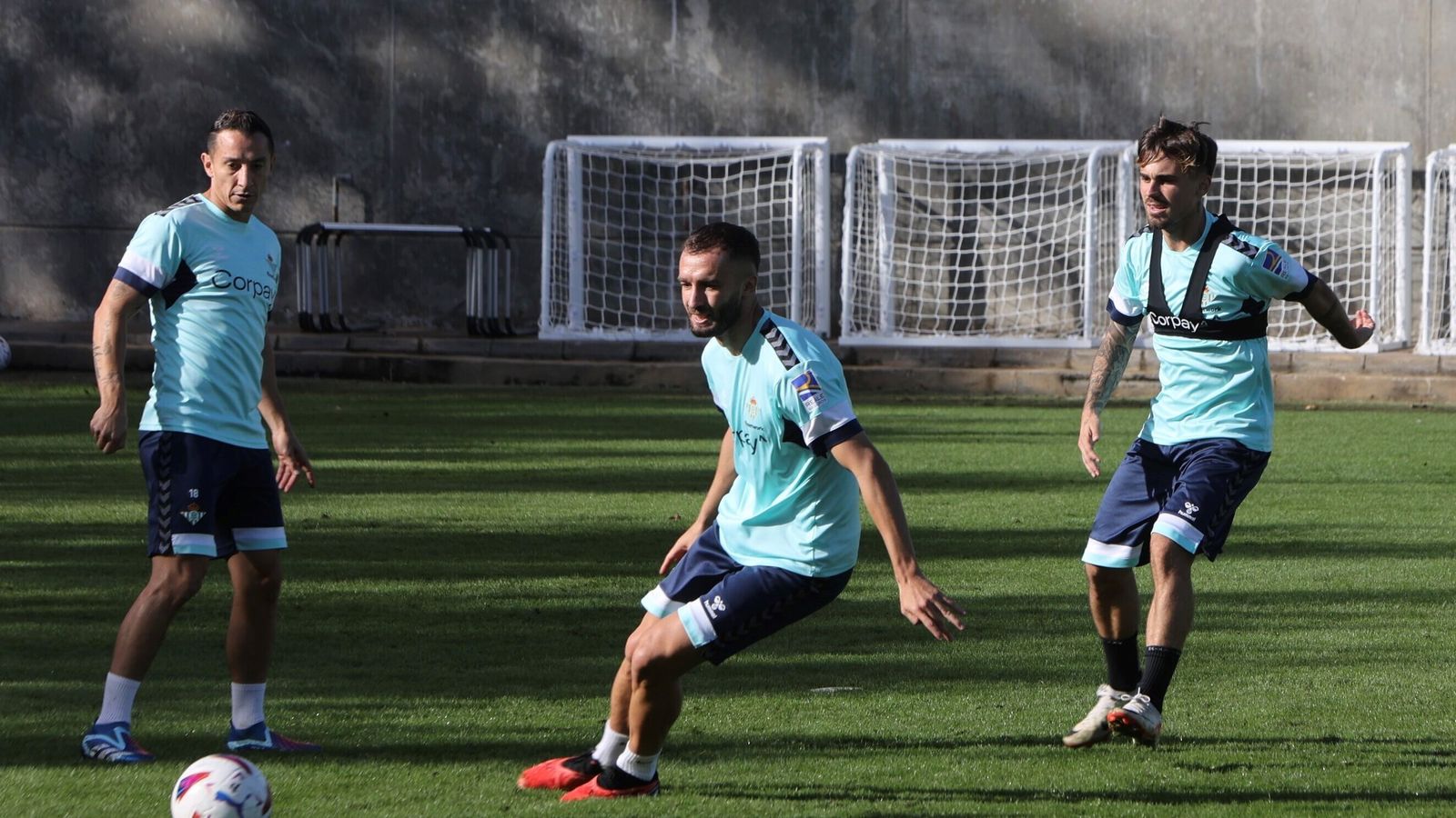 Pezzella busca la pelota, ante Rodri y Guardado.