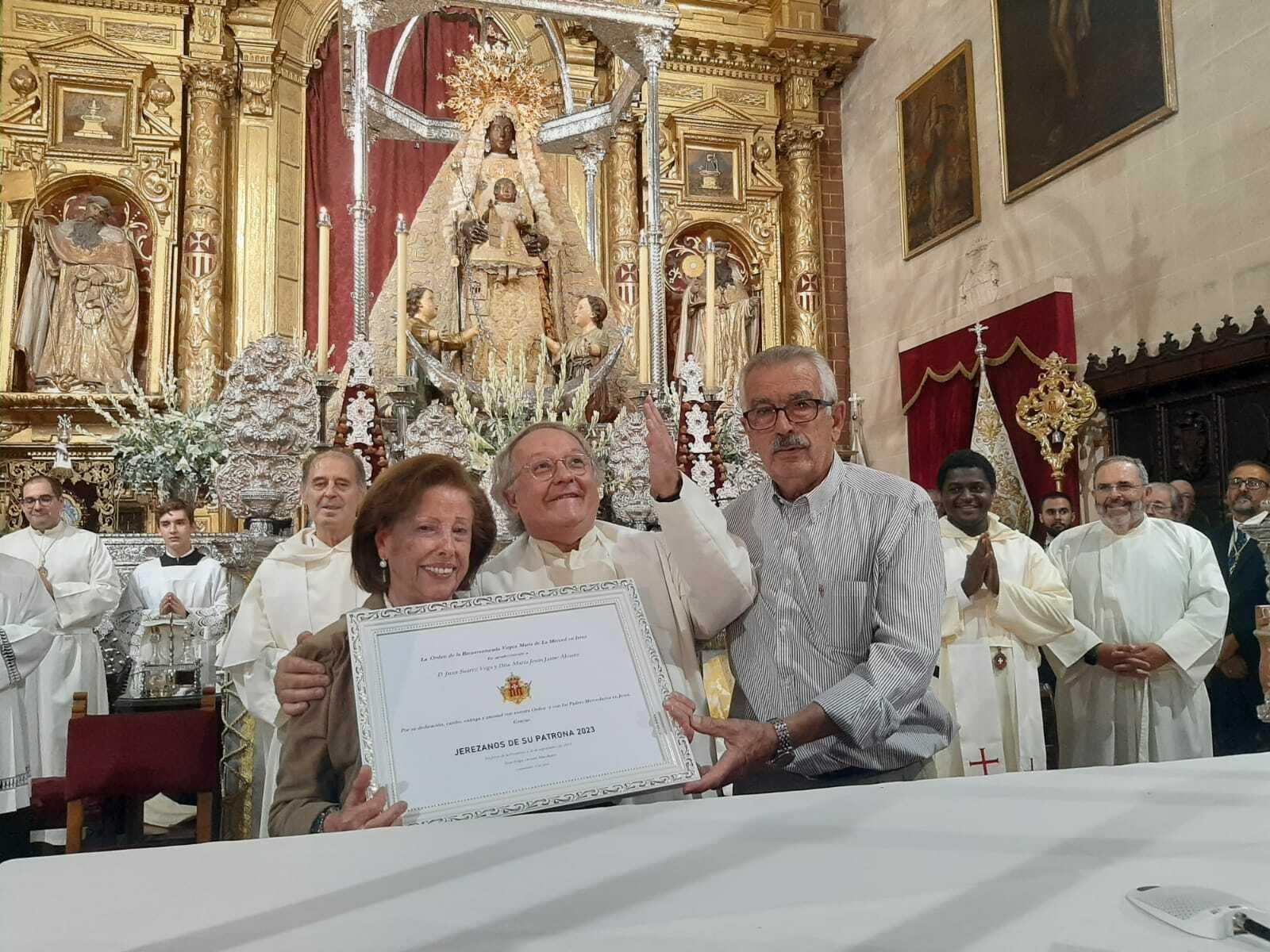 El matrimonio Suárez Jaime junto al padre Felipe Ortuno en el momento de la entrega del diploma.