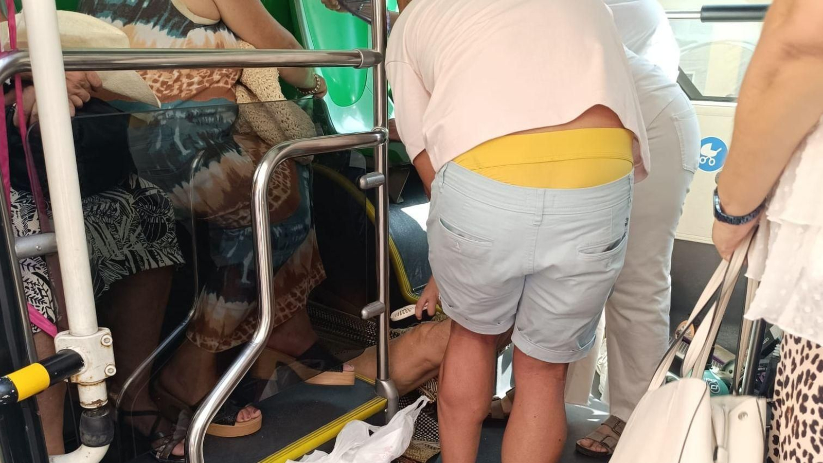 Momento en que varios usuarios del autobús urbano atienden a una mujer que se desvaneció.