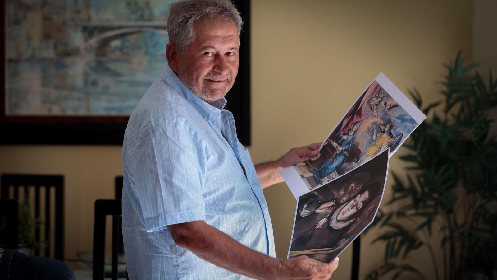 El detective Juan Carlos Arias, con algunas láminas de cuadros que él cree falsos.