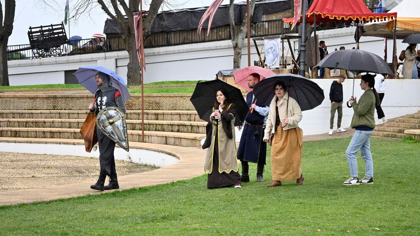 Varias personas se refugian con sus paraguas de la lluvia.