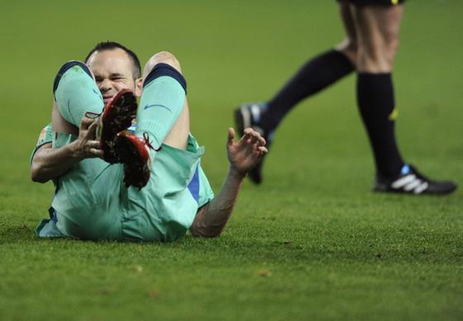 Iniesta se duele de un golpe. / Reuters