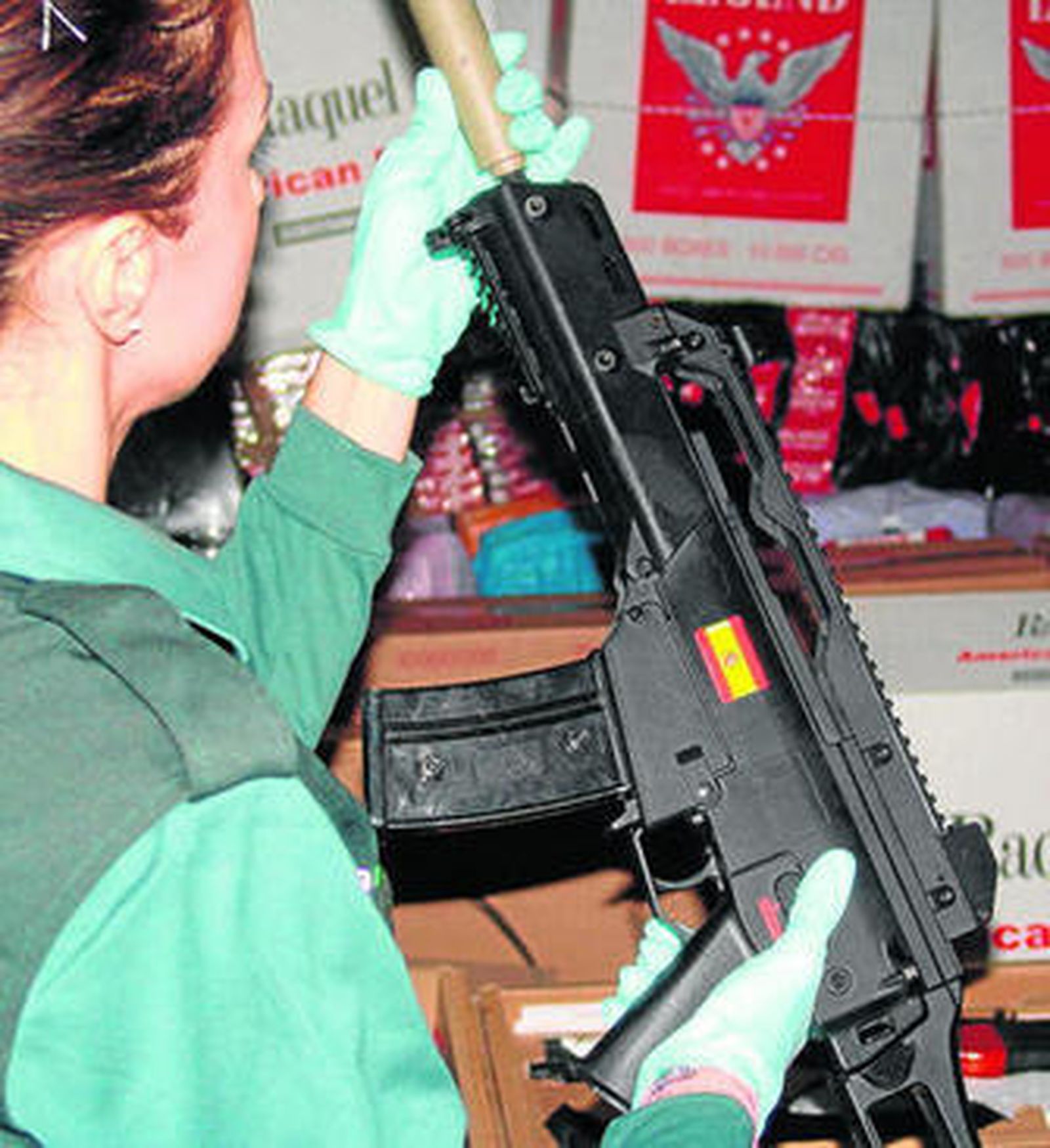 Una agente muestra una de las armas intervenidas en la operación Pisonova.