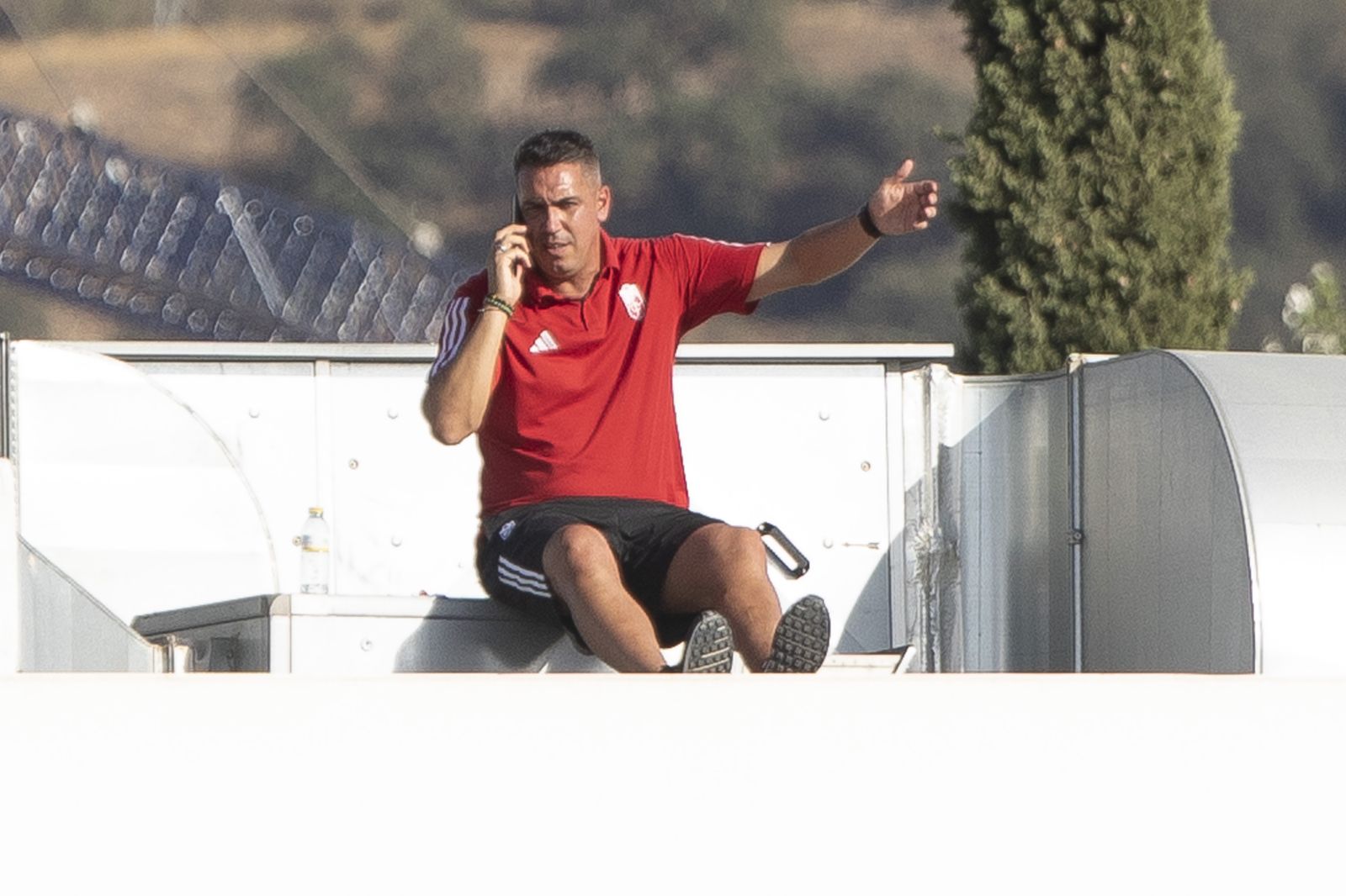 Milla charla por el móvil desde la grada de la Ciudad Deportiva.