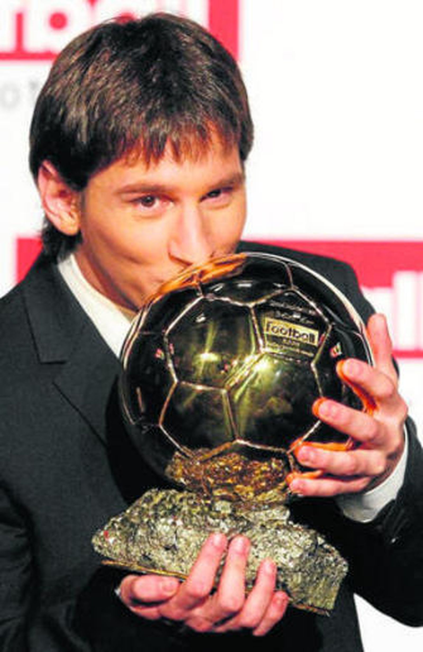 Messi, besando el Balón de Oro ayer en París.