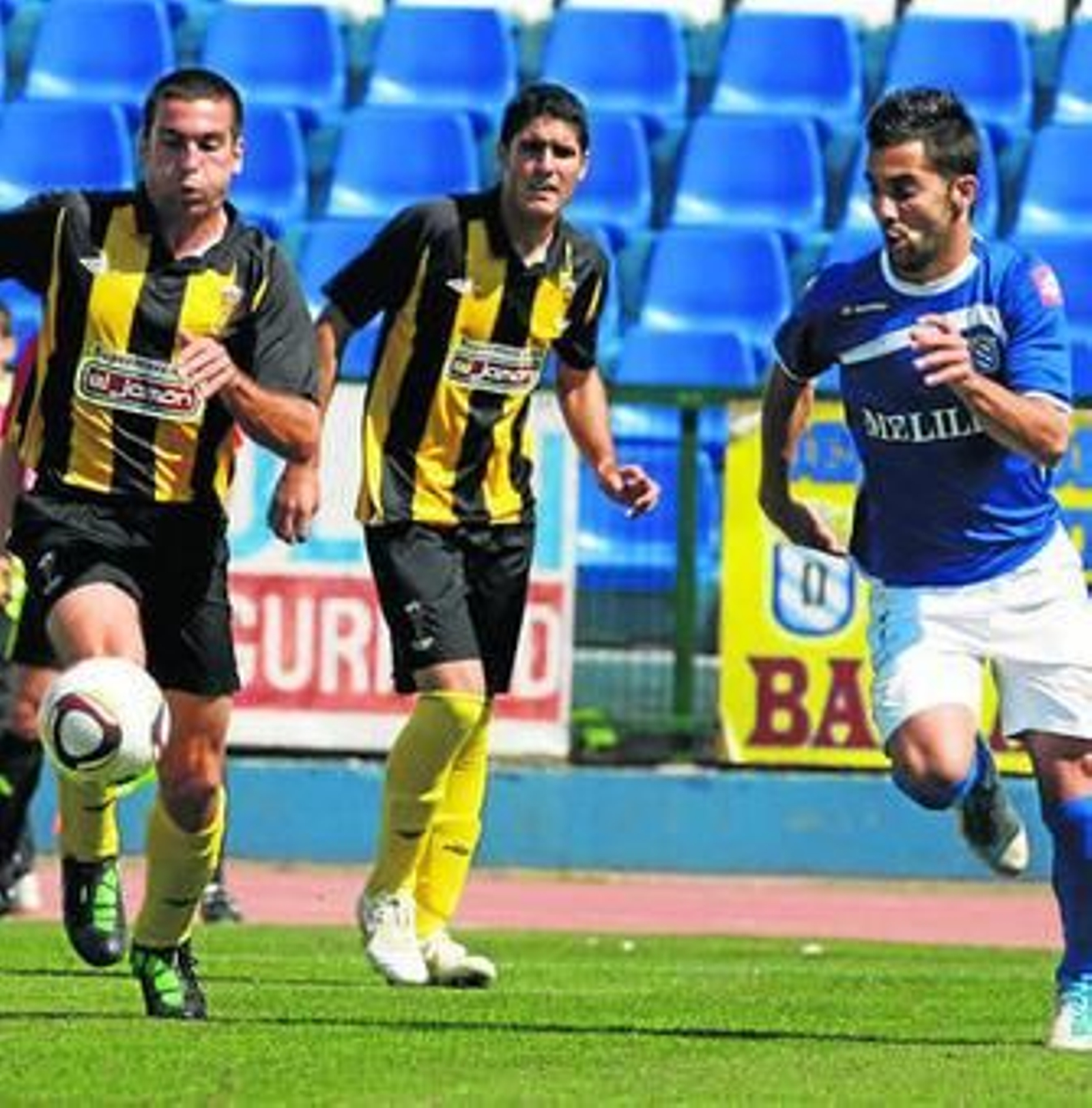 Velasco (d), jugador del Melilla, intenta llevarse el balón.