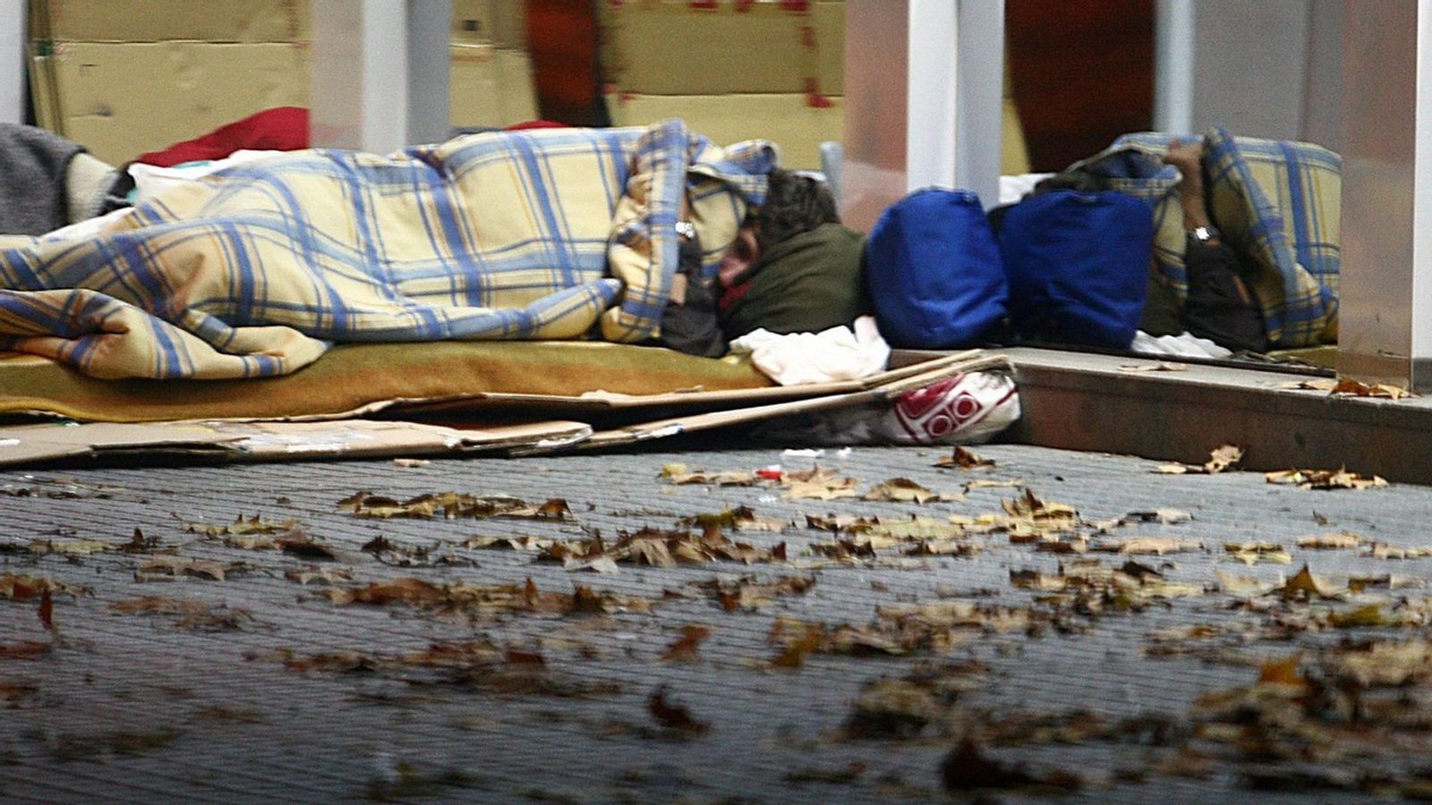 Dos personas sin hogar durmiendo junto a la estación de autobuses de Huelva.