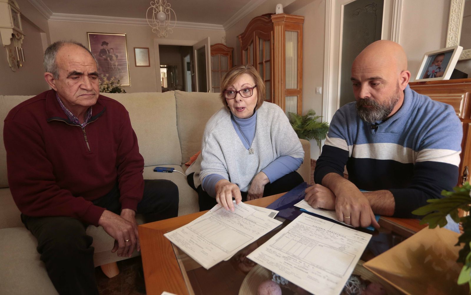 Manuel, su mujer, Desamparado Humanes, y su hijo, Juan Manuel, muestran la historia clínica del parto hace 42 años.