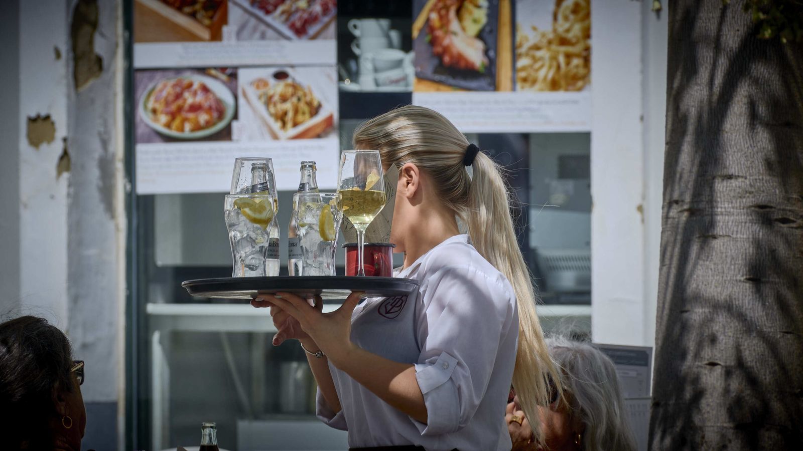 Una profesional de la hostelería, con una bandeja.
