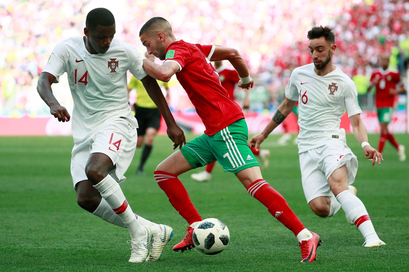 William Carvalho y su compañero en Portugal Bruno Fernandes tratan de parar el avance del marroquí Hakim Ziyech durante el Mundial de Rusia.