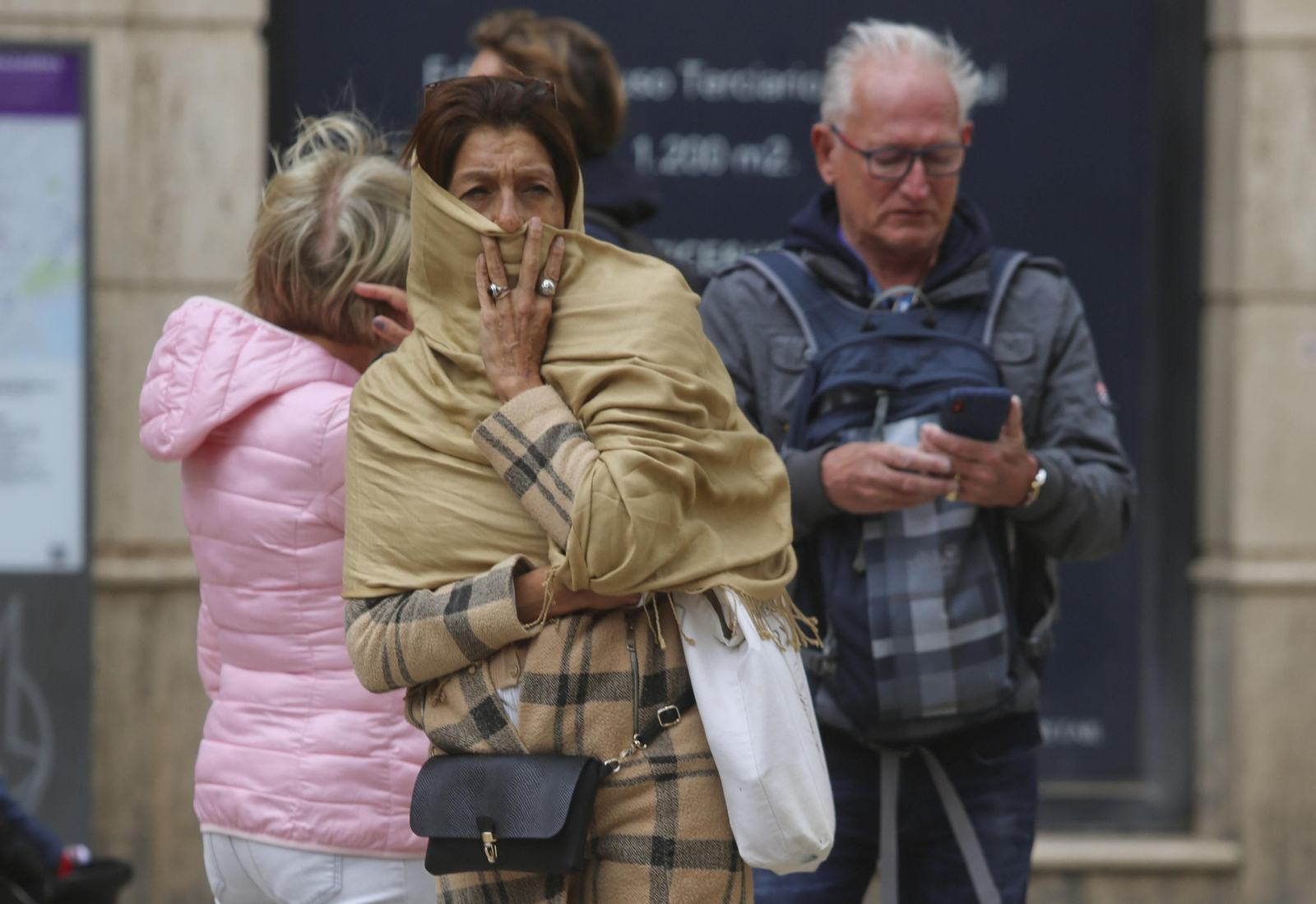 Una mujer se abriga con una bufanda.