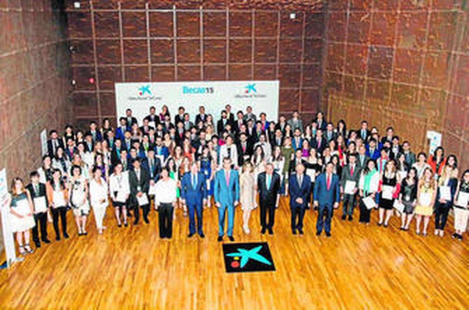 Don Felipe y doña Letizia, en el centro, posan junto a los 120 becados por la entidad.