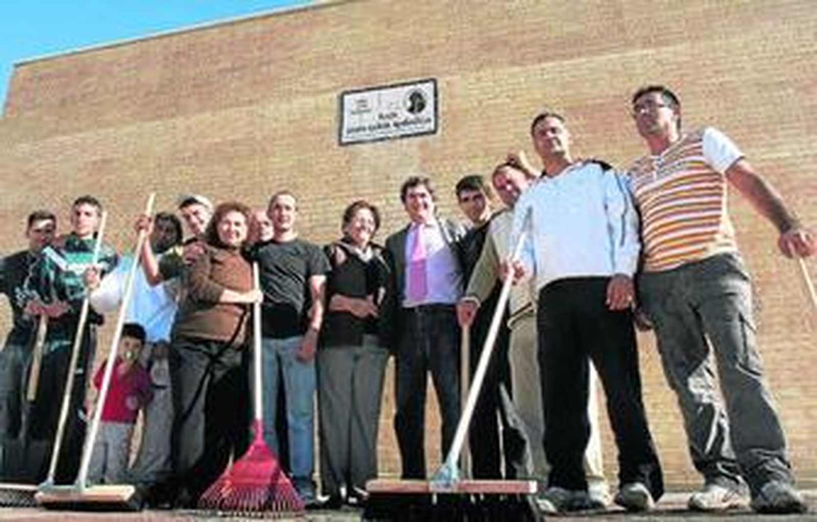 Representantes vecinales y políticos posan, días atrás, junto a los desempleados voluntarios en la plaza de 'Pepa la del polígono'.
