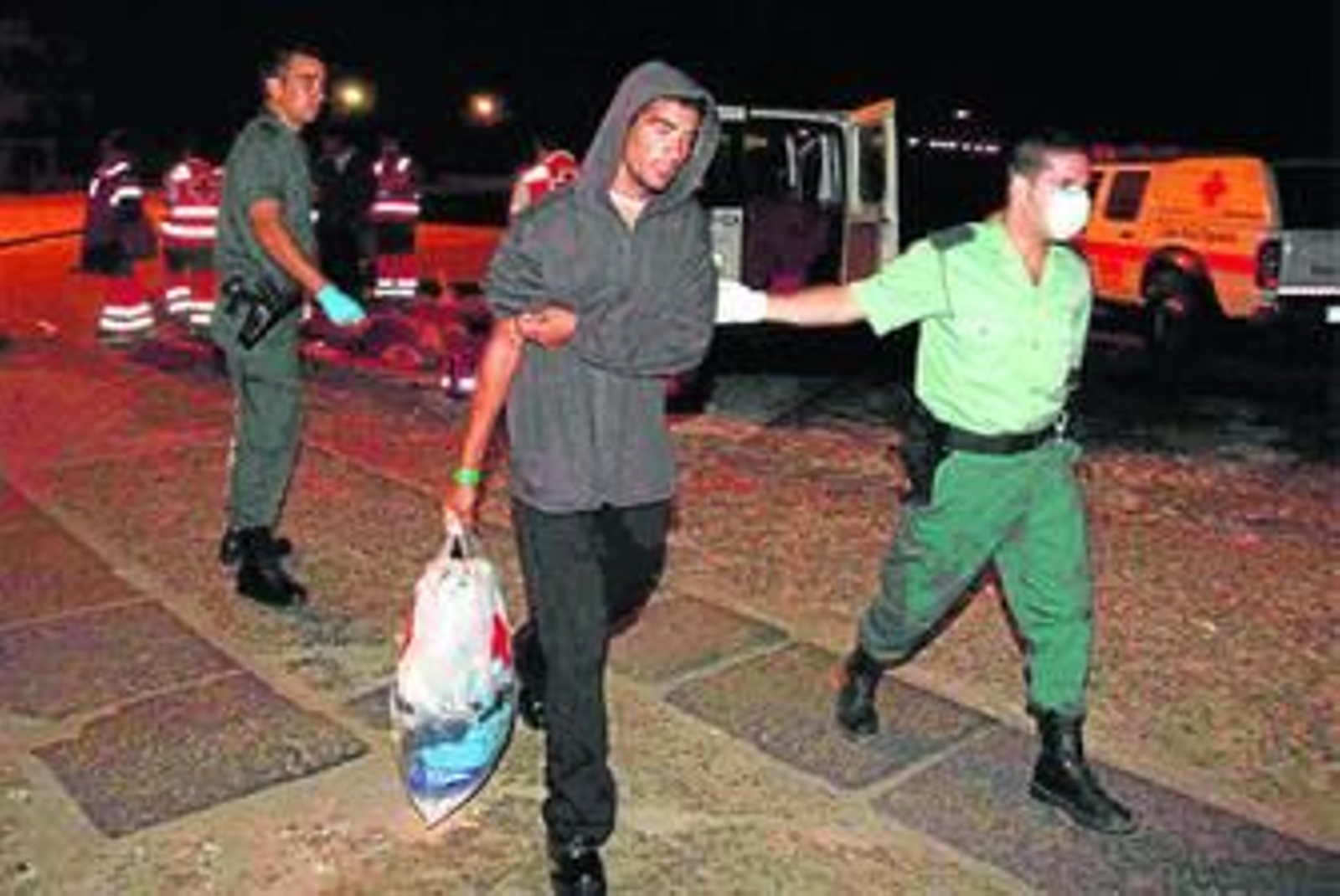 Un guardia civil traslada a un inmigrante, ayer, en el puerto.