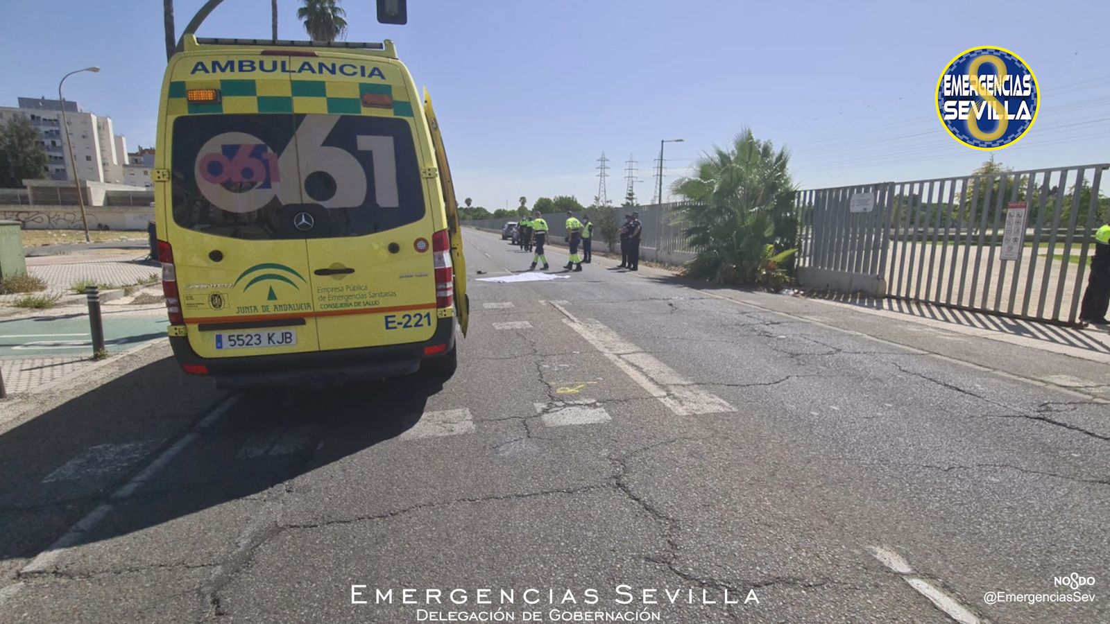 Una ambulancia del 061 y la víctima, cubierta por una sábana en el asfalto.