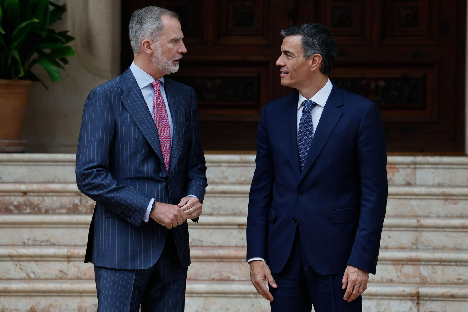 Felipe VI charla con el presidente del Gobierno, Pedro Sánchez, antes de su reunión en el Palacio de Marivent.