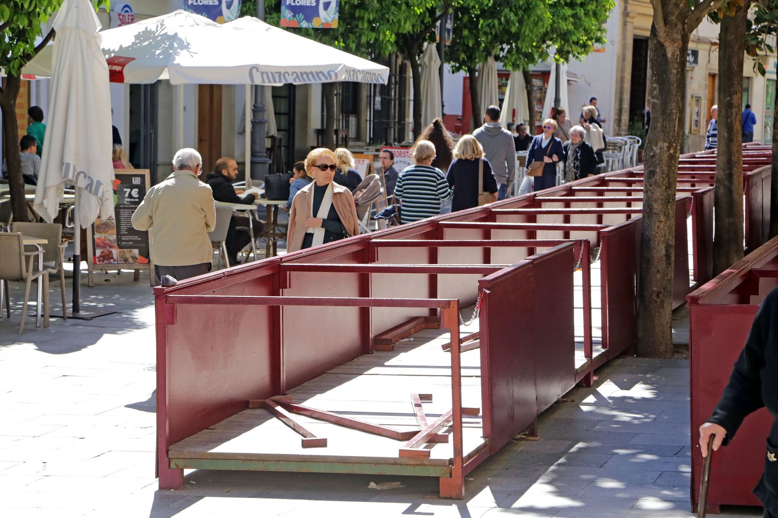 Viandantes en la calle Larga con bares a un lado y los palcos de Semana Santa a otro.