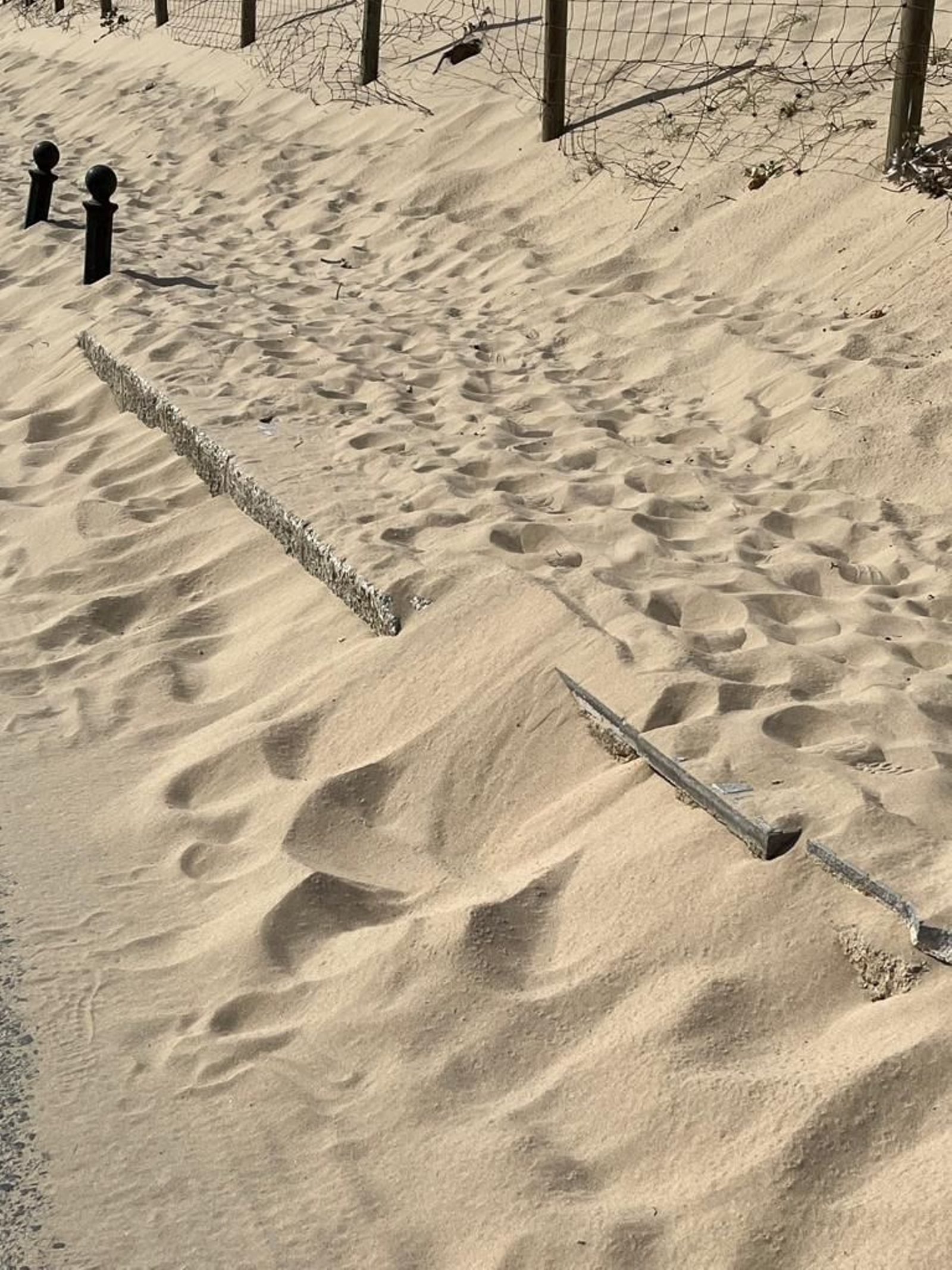 La acera cubierta por la duna de Cortadura.