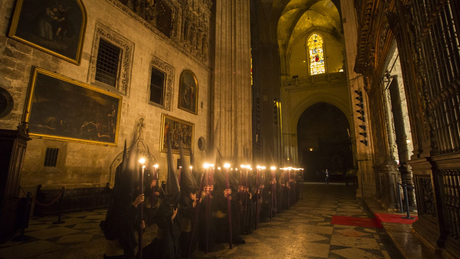 Nazarenos de la Hermandad del Silencio arrodillados ante el Monumento.