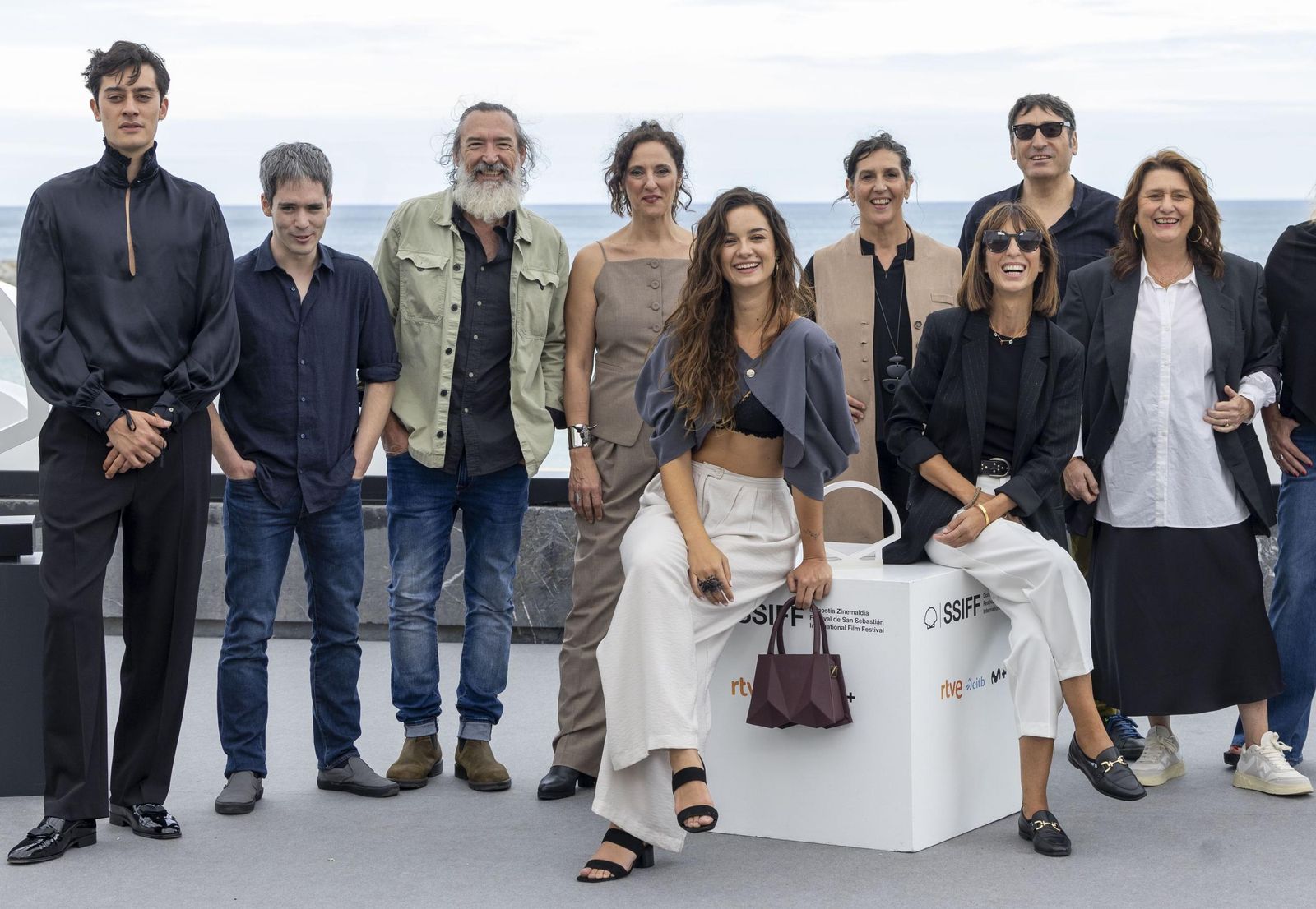 Elvira Míguez, de pie ante el cubo, escritora y directora de 'La sombra de la tierra', con el elenco de la serie en el Festival de San Sebastián